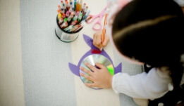a little girl holding a pen and drawing