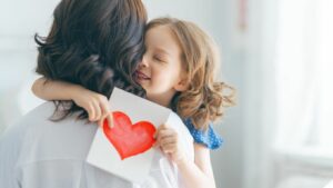 bambina che da un biglietto per la festa della mamma in inglese